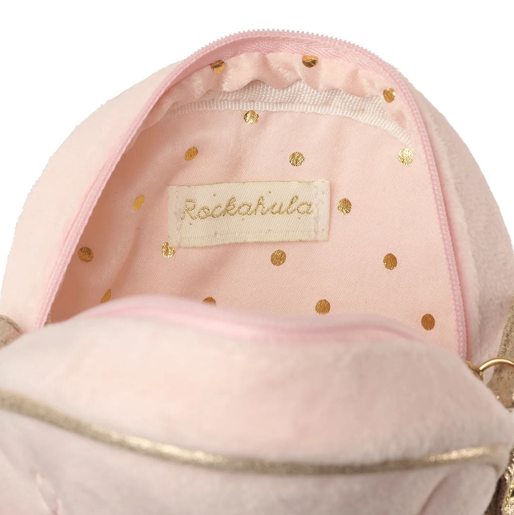 Close-up of the interior of a soft pink bag with gold polka dots and a visible Rockahula brand label sewn into the lining.