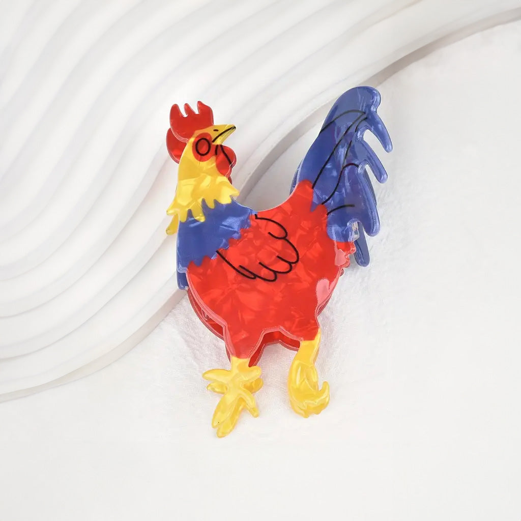 Colourful rooster-shaped claw clip on a white textured background