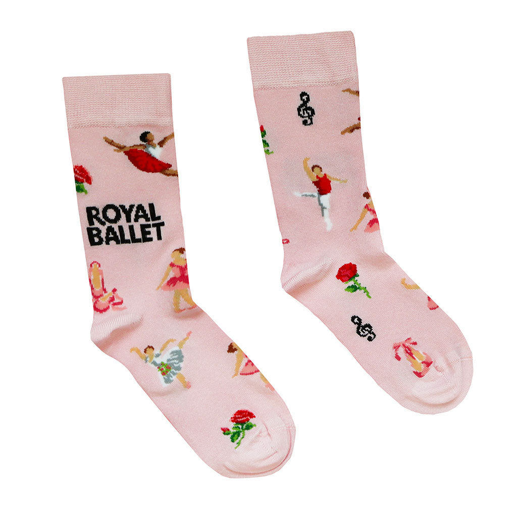 A pair of light pink bamboo socks featuring ballerina dancers, musical notes, roses, ballet shoes, flowers and the text 'ROYAL BALLET' on a white background.