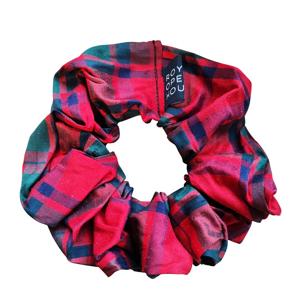 Red and green plaid scrunchie with a brand tag on a white background
