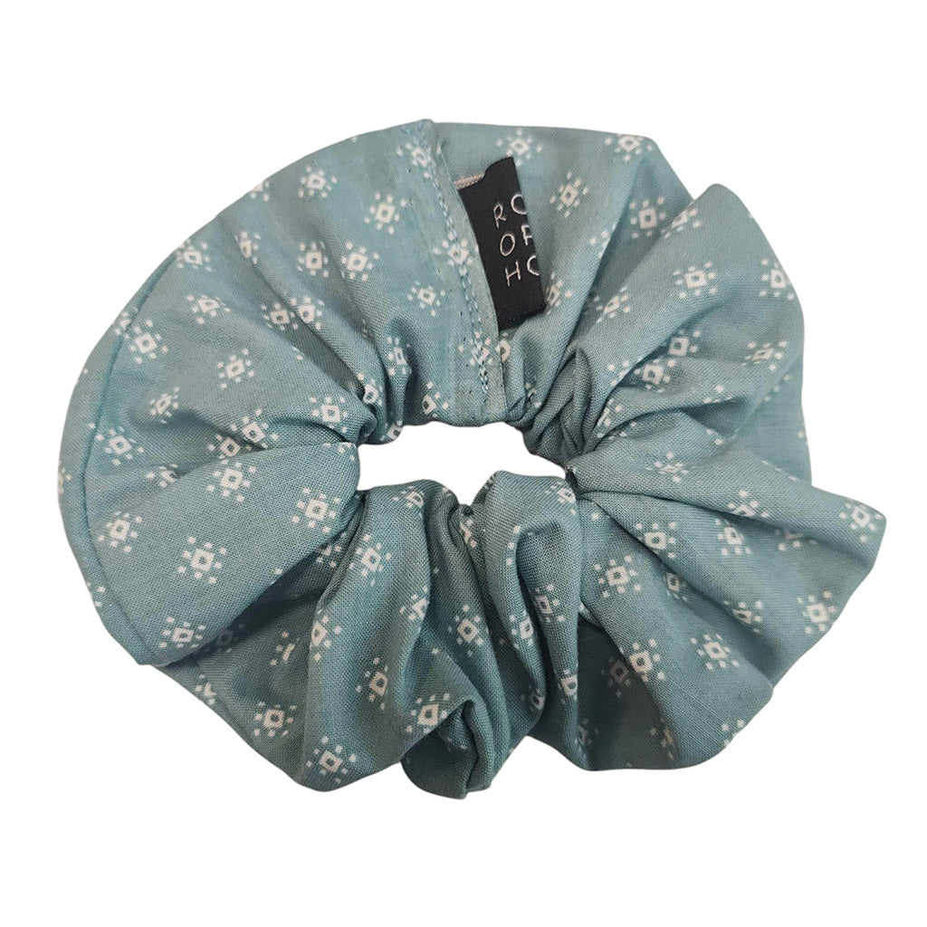 Blue floral scrunchie with a brand label ROH on a white background