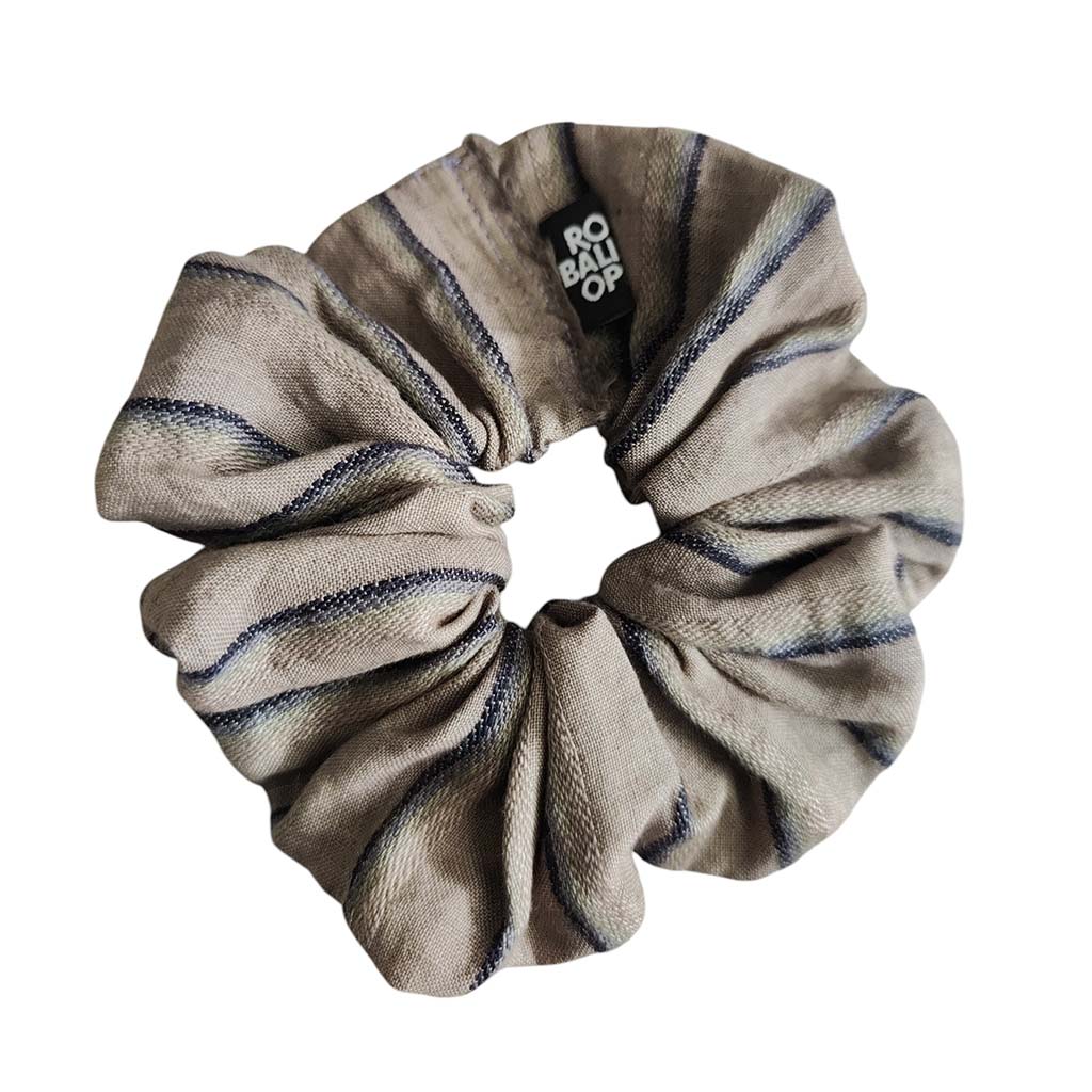 A fabric scrunchie in a taupe-beige colour with dark stripes, featuring a black brand tag that reads 'RBO'.