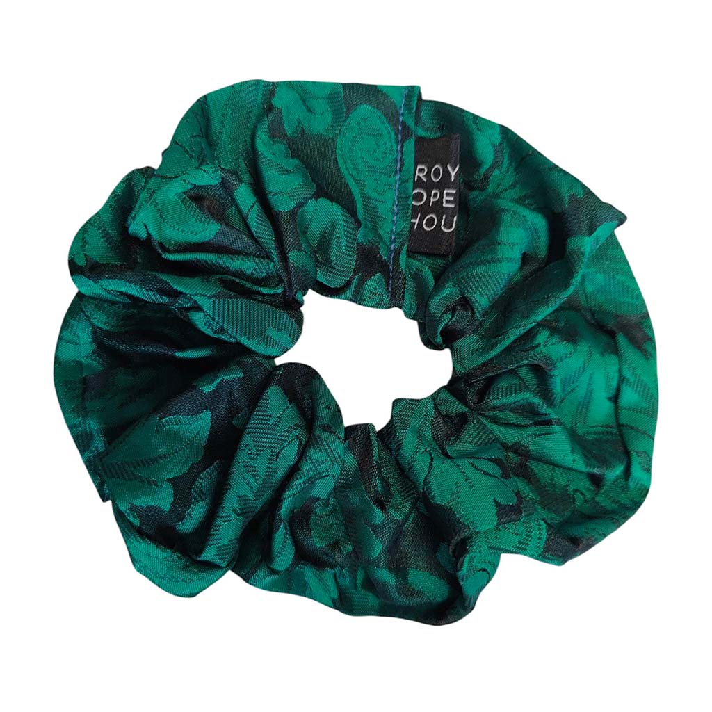 Green scrunchie with a brand tag on a white background