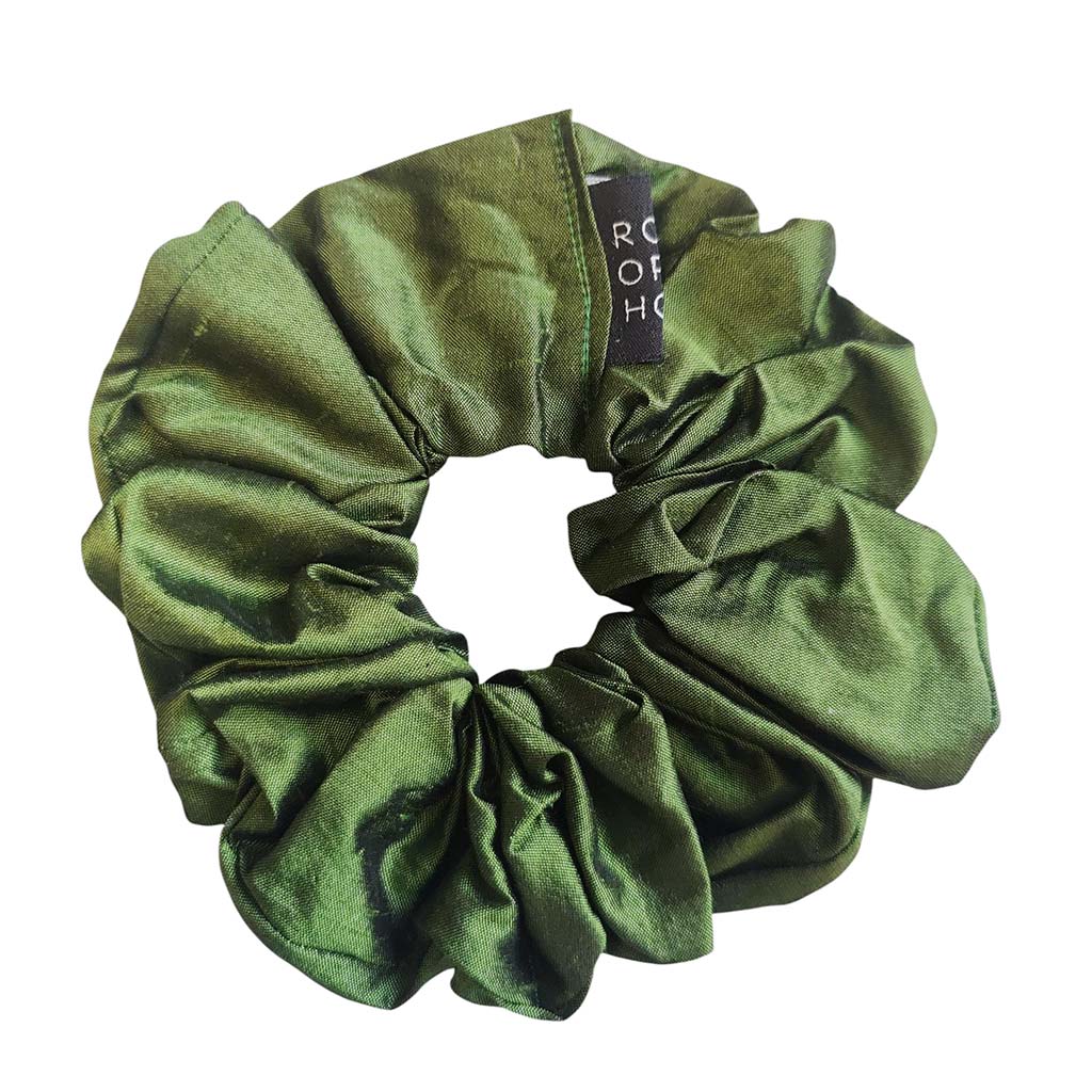 Green scrunchie with a brand tag on a white background