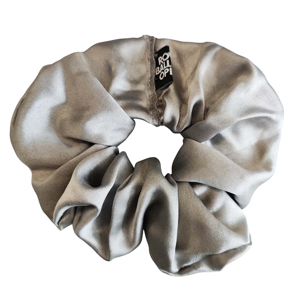 A metallic silver scrunchie with a black brand tag reading 'RBO' on a plain white background.