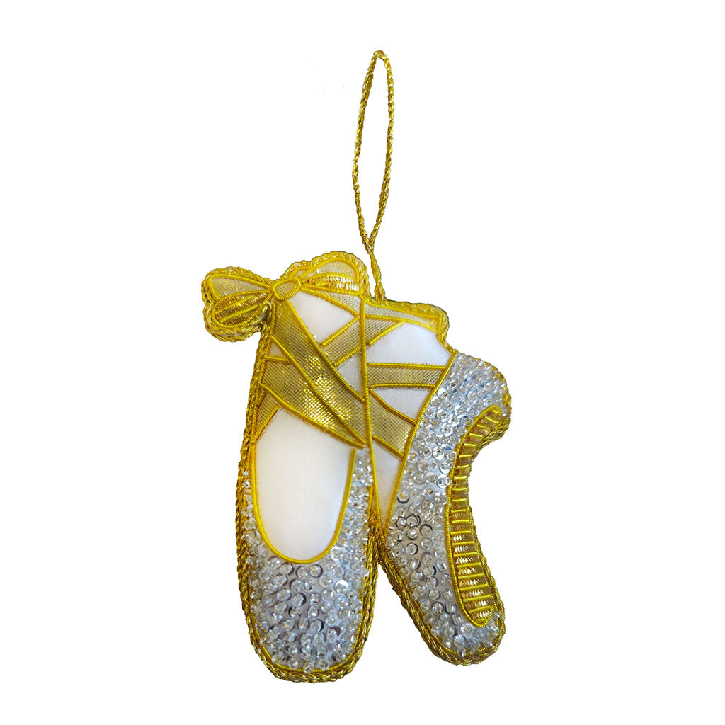 Decorative ballet shoe decoration with gold and silver details on a white background