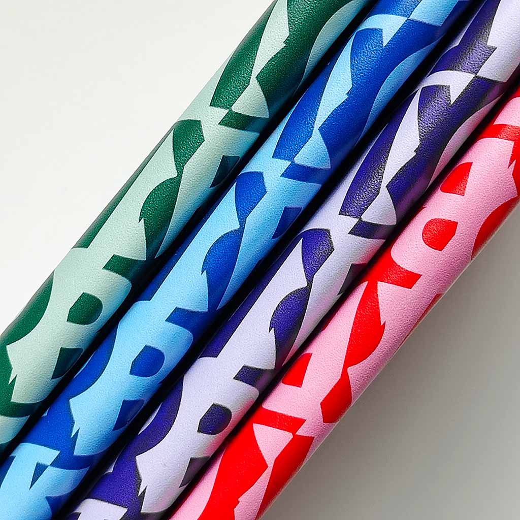 Four colourful patterned spines of the Signature notebooks  on a light gray background