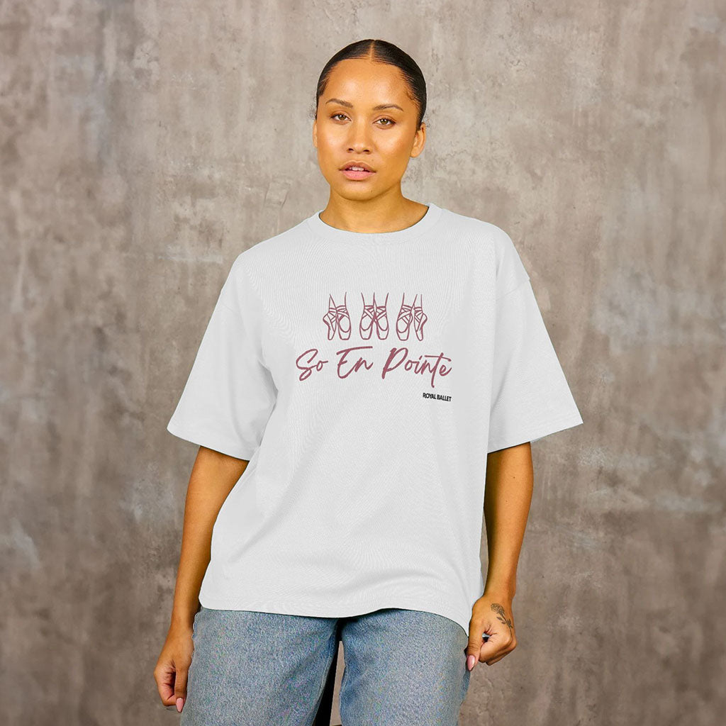 Person wearing a white t-shirt with &#39;So En Pointe Royal Ballet&#39; text and graphics on a textured gray background
