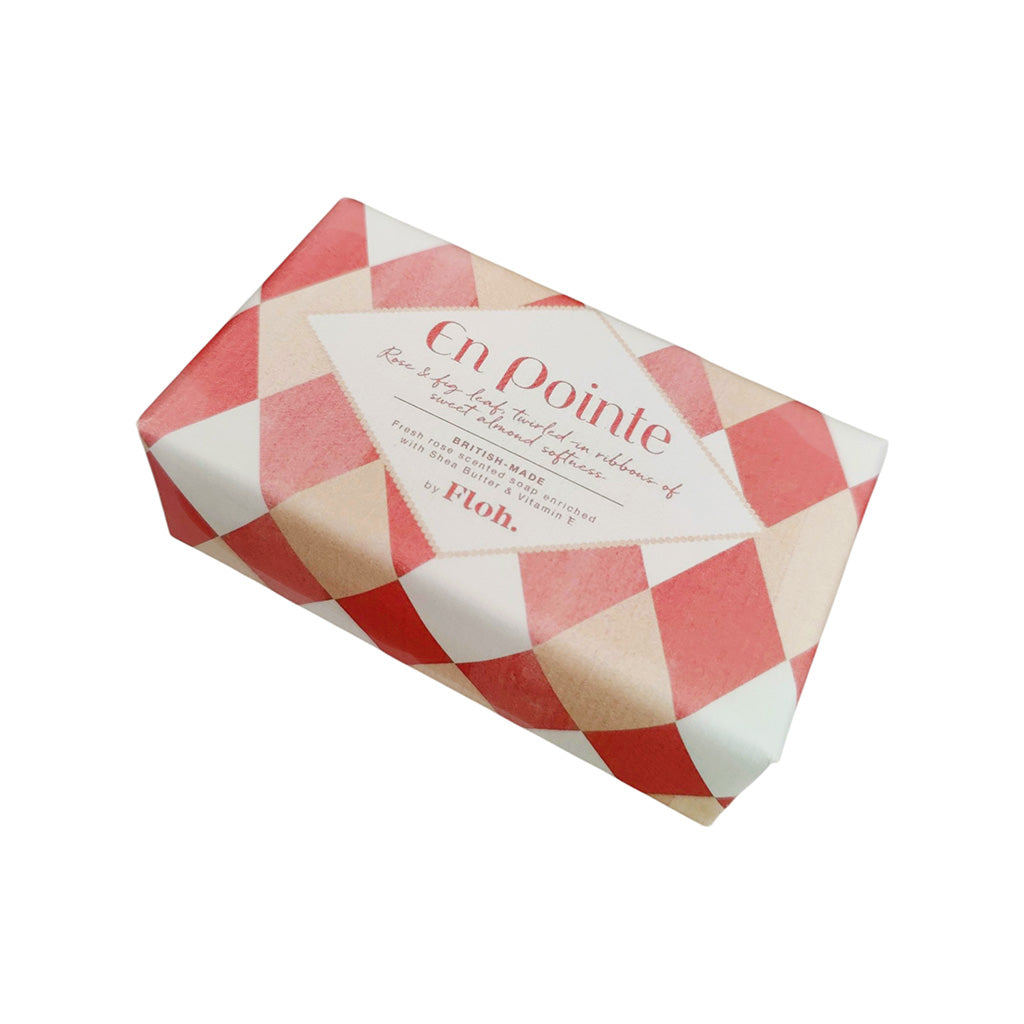 A wrapped bar of soap from the brand Floh, featuring a red and cream diamond-patterned wrapper with a central cream label that reads 'En pointe'.