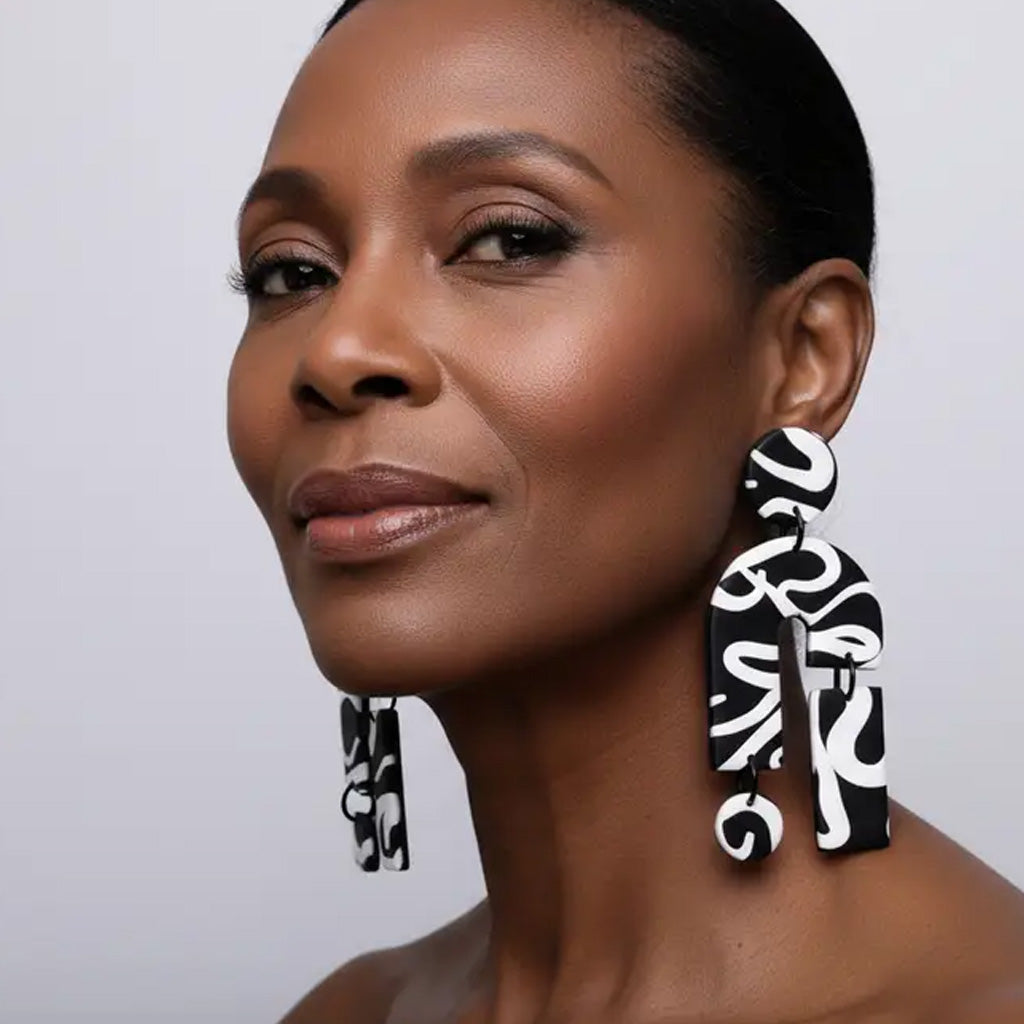 woman wearing large statement black and white abstract earrings