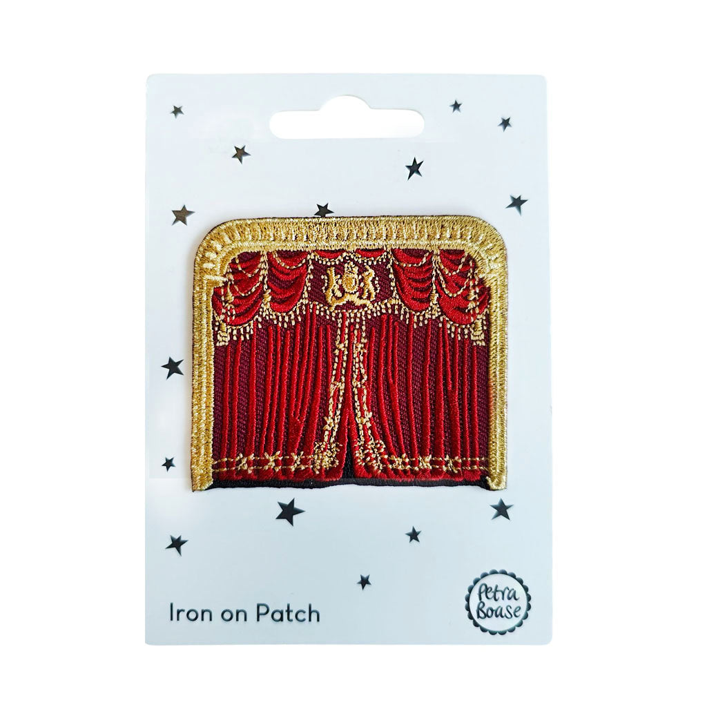 Red theatre curtain iron-on patch on a white card with 'Petra Boase' branding.