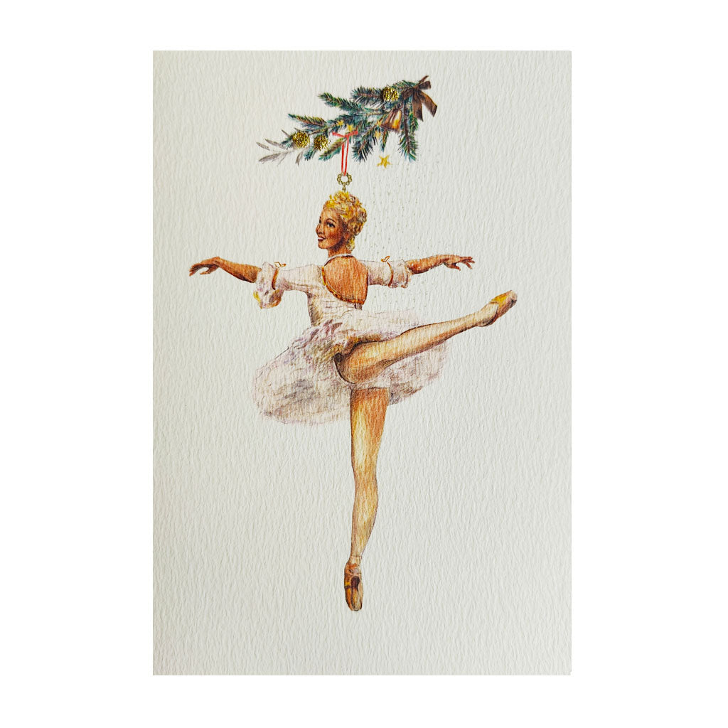 A handmade greeting card featuring a watercolour illustration of a ballerina in a white tutu suspended from a decorated Christmas tree branch, centred on a textured off-white background.