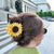 Yellow sunflower-shaped hair clip on a white background