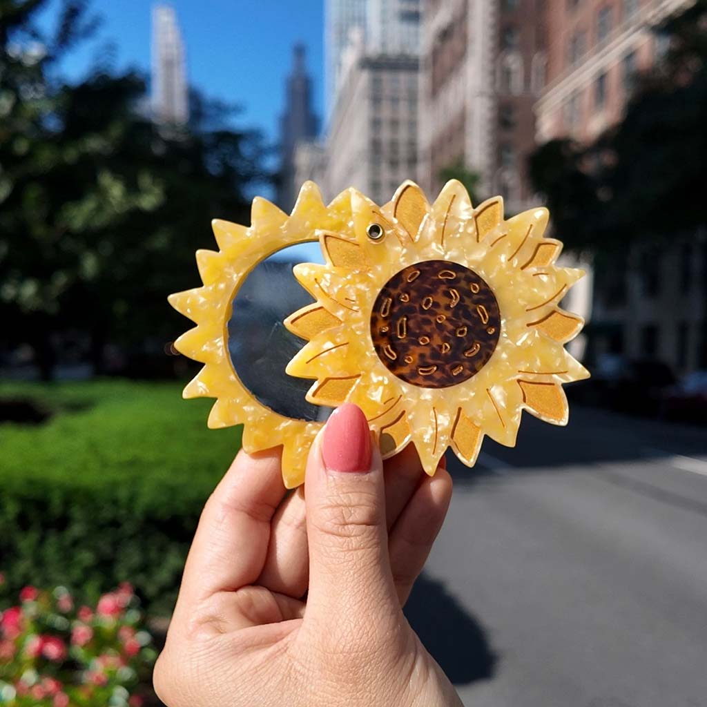 Sunflower-shaped compact mirror on a white background