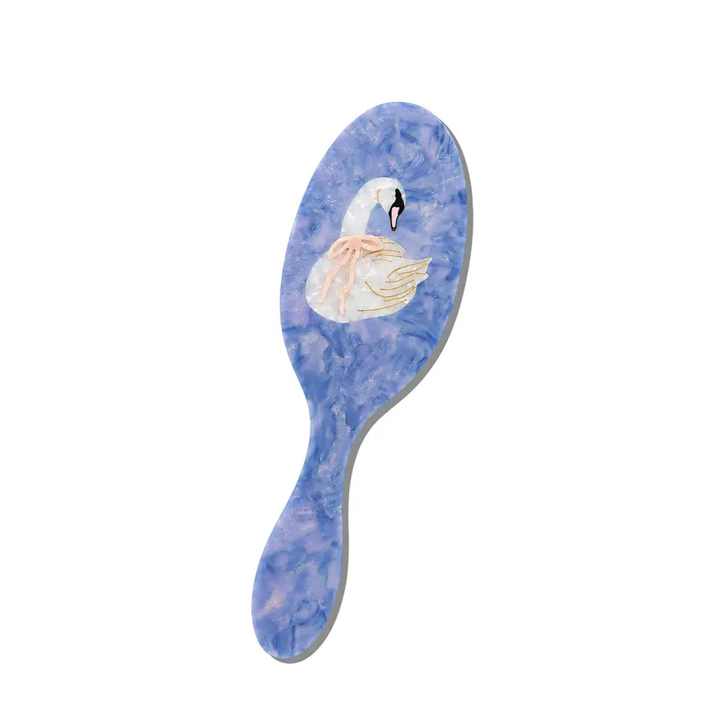 A blue hair brush with a blue marbled pattern and an illustration of a white swan wearing a pink bow on the back, shown on a plain white background.