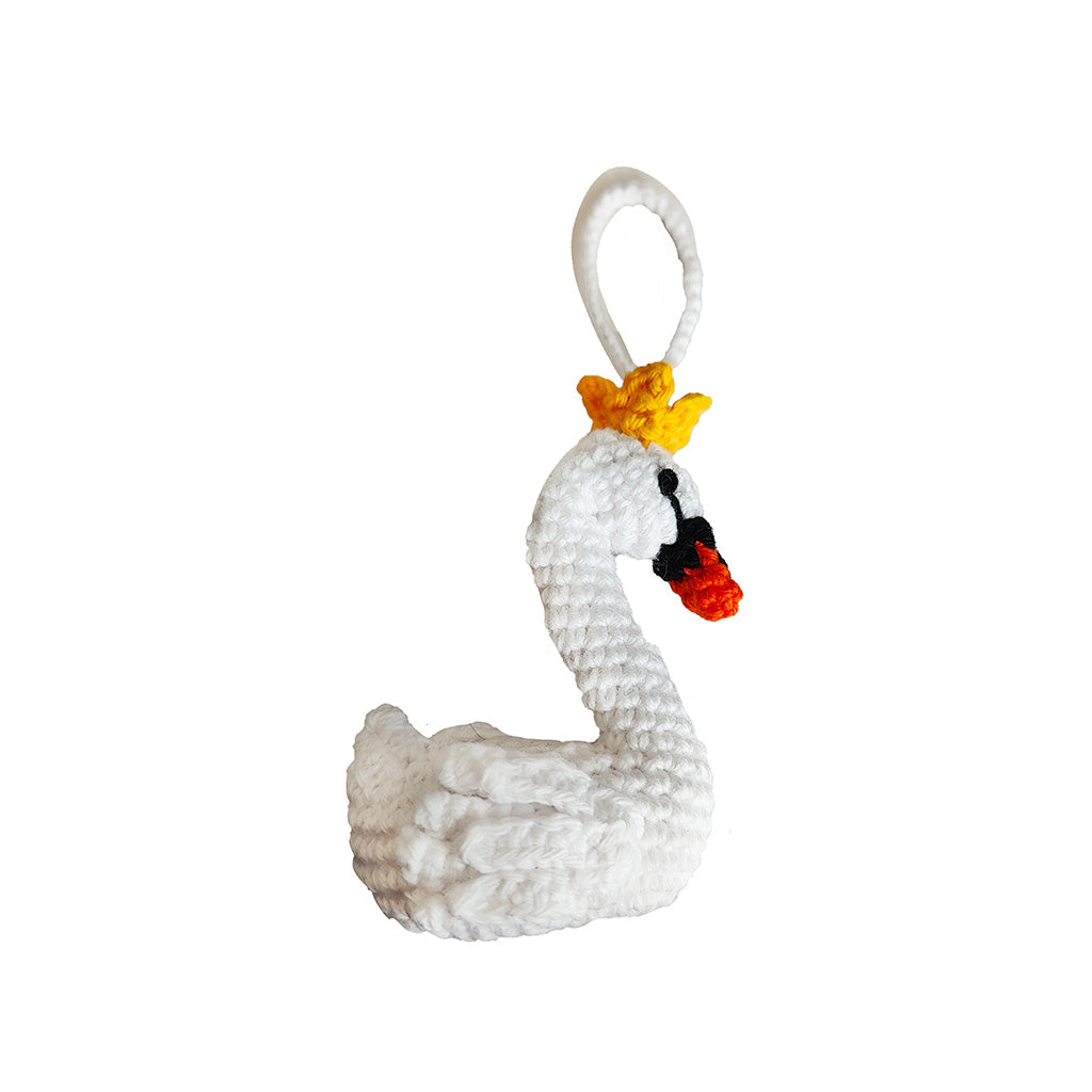 white crochet swan decoration with orange beak and yellow crown on a white background
