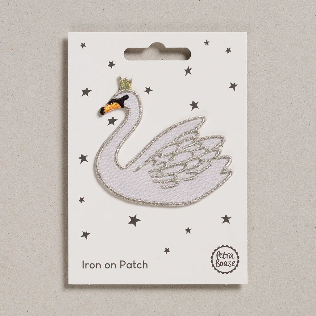 embroidered Iron on Swan patch on white card with stars on a grey background
