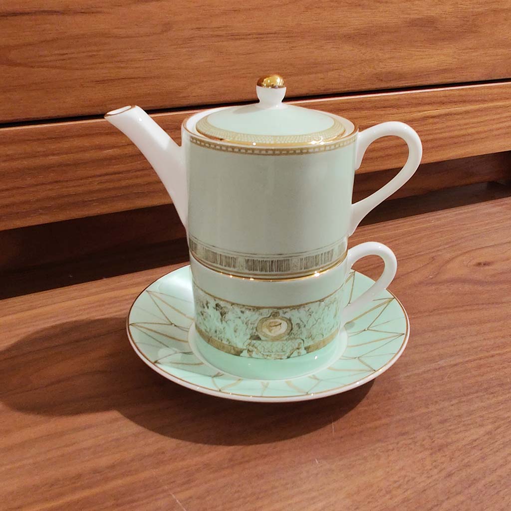 tea for one  - teapot, cup and saucer on a wooden surface