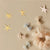A set of Sparkly Tulle Bow Clips on white card with black dots, against a white background. There are four clips shaped into bows, the top two are a pale pink and the bottom two are a light blue. All four have a glittery gold band around the middle of the bow. 