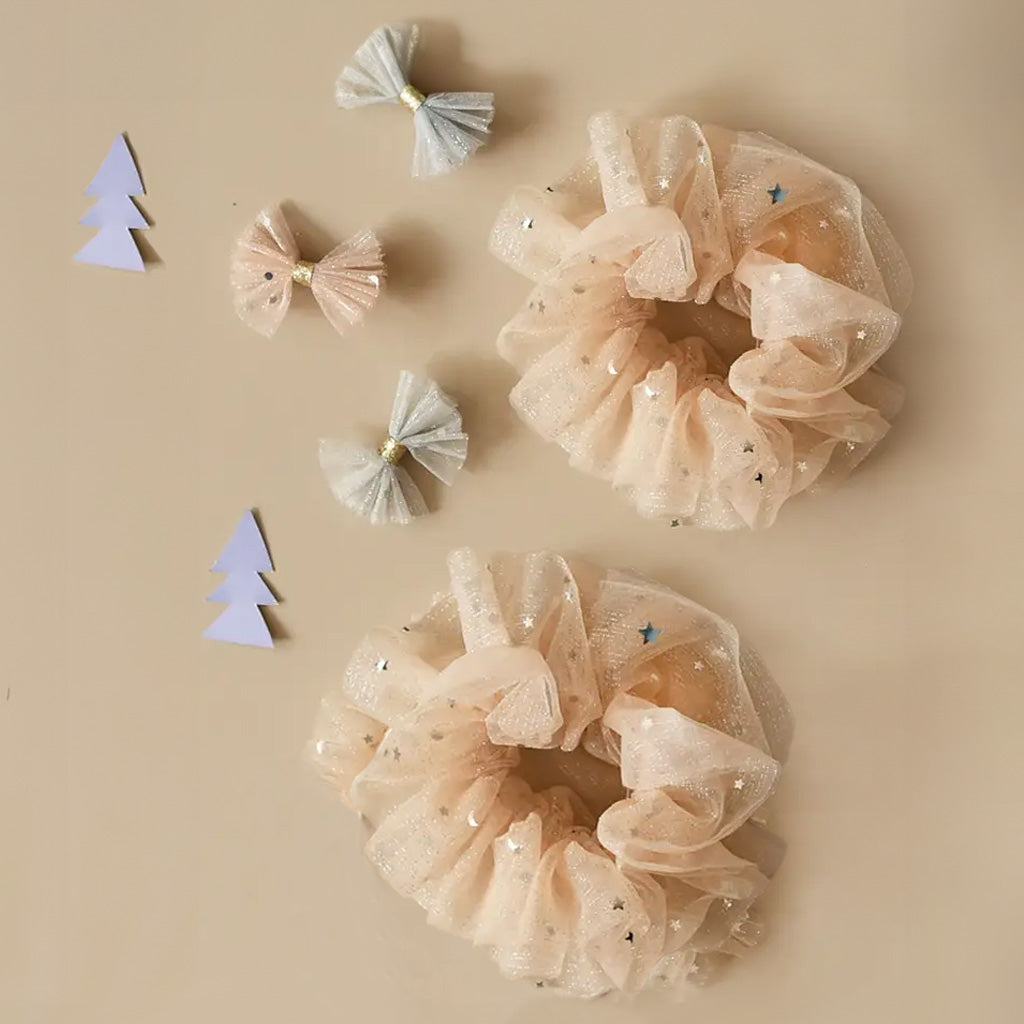 A Sparkly Tulle Scrunchie made from beige tulle fabric with star patterns on a white background.