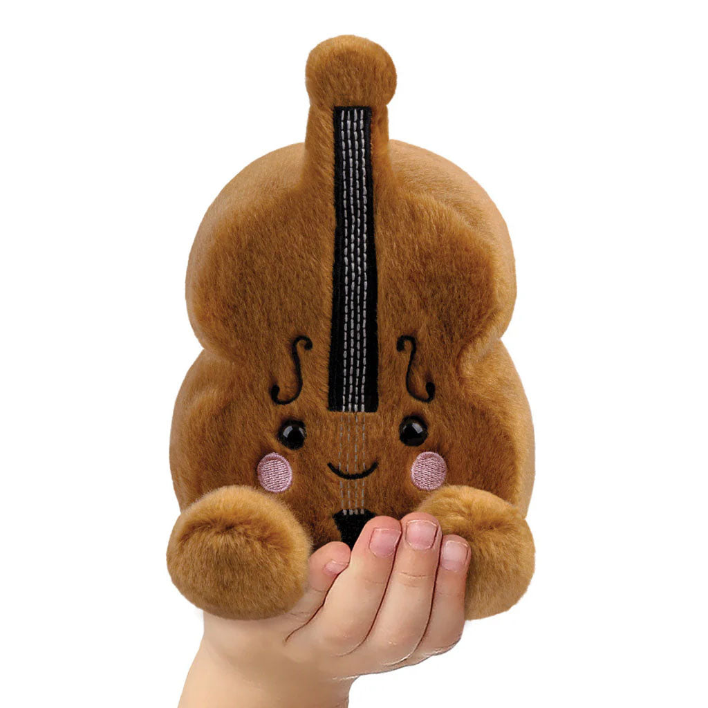 childs hand holding a violin shaped soft toy on a white background