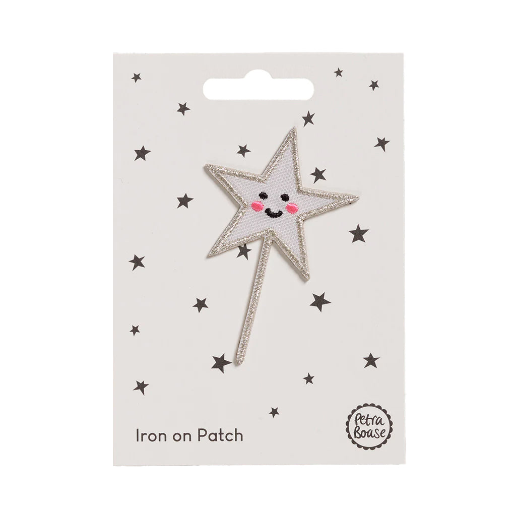 Star-shaped iron on patch with a smiling face on a white card with star patterns, branded &#39;Petra Boase&#39;.