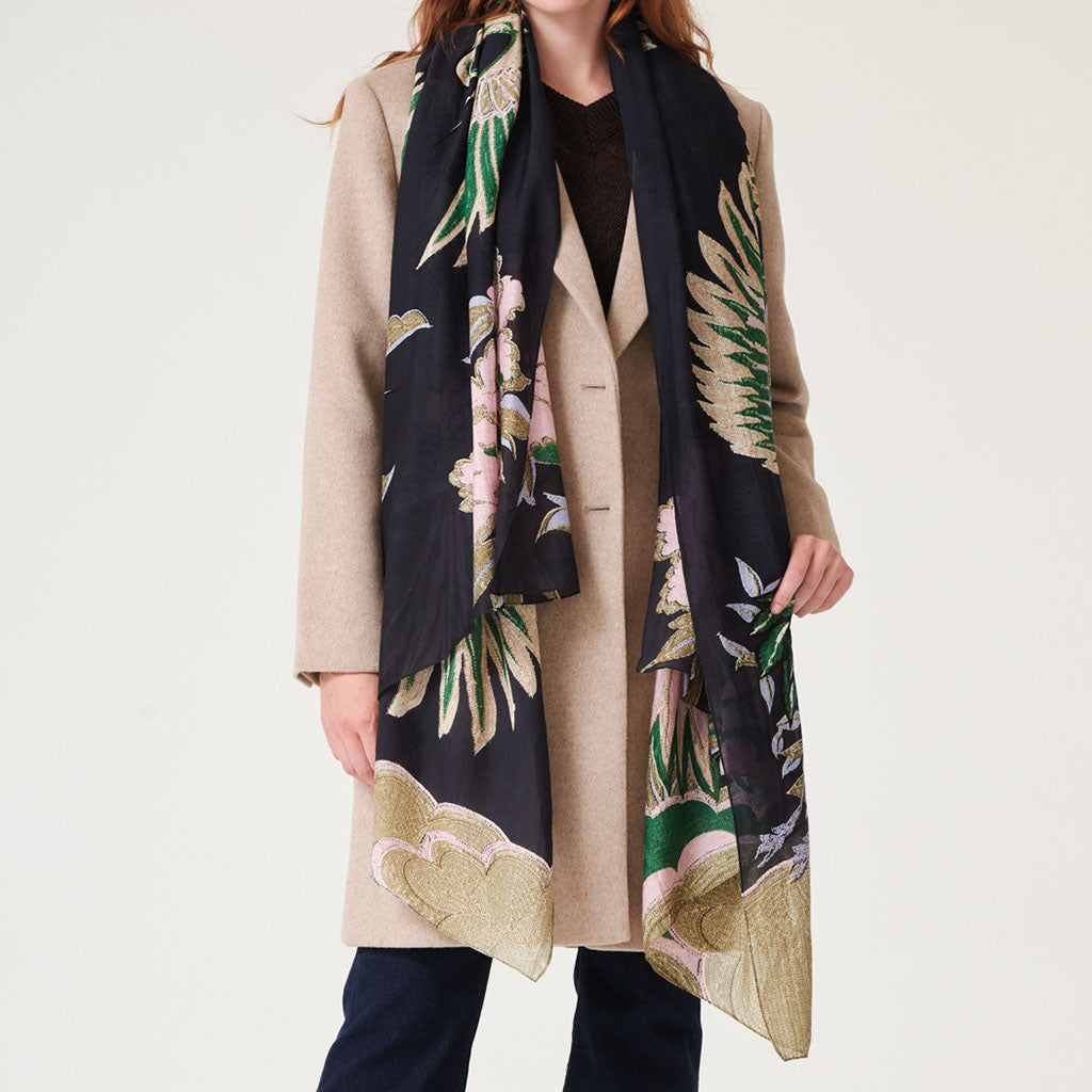 Person wearing the crane emerald patterned scarf with a neutral background