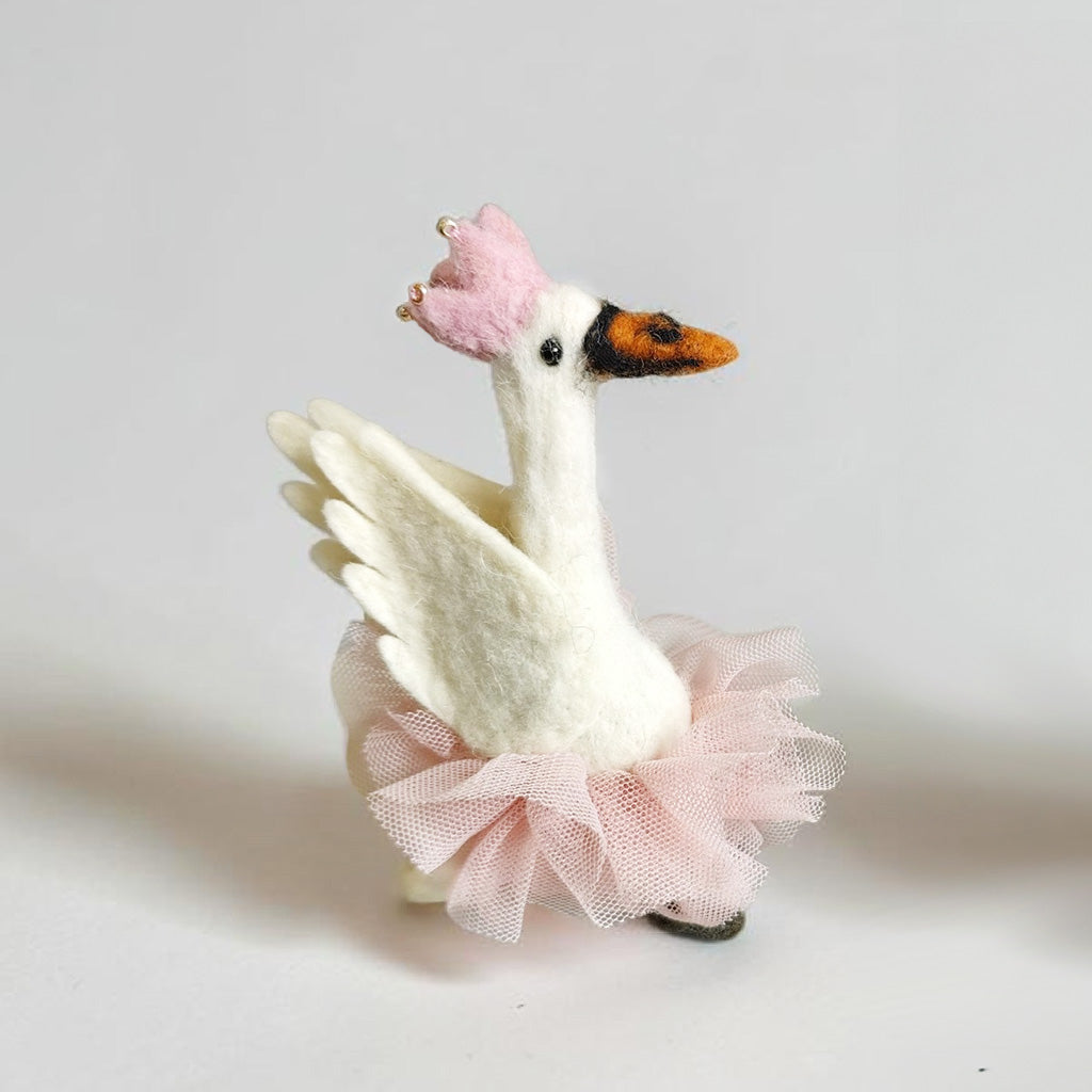 White swan decoration with a pink tutu on a light gray background